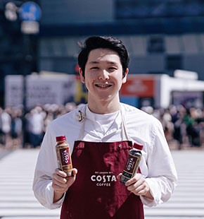 japanese-team-member-holding-costa-bottles